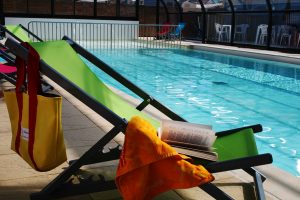 Deckchairs at the edge of the campsite with swimming pool in Loire Atlantique