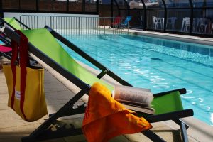 Deckchairs at the edge of the campsite with swimming pool in Loire Atlantique