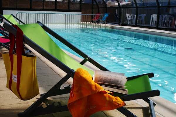 Bain de soleil au bord de la piscine couverte du camping à Saint-Michel-Chef-Chef